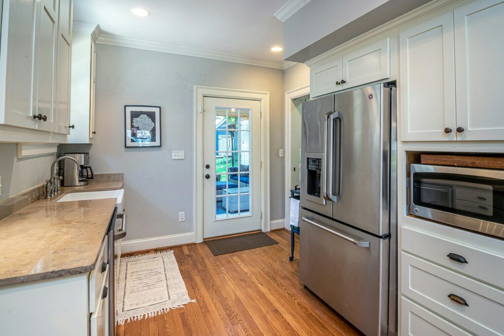 Bright kitchen with stainless steel appliances and wooden flooring.